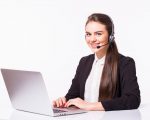 young-woman-working-in-office-with-laptop-and-headphones-on-white-wall-customer-service-and-call-center